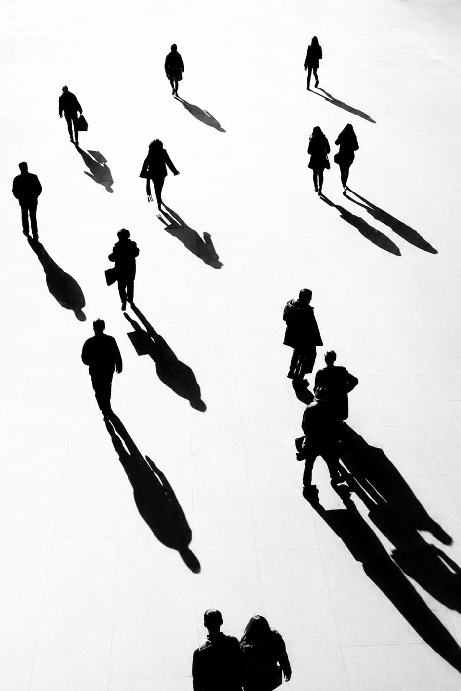 Menschen von oben auf einem hellen Platz, lange Schatten